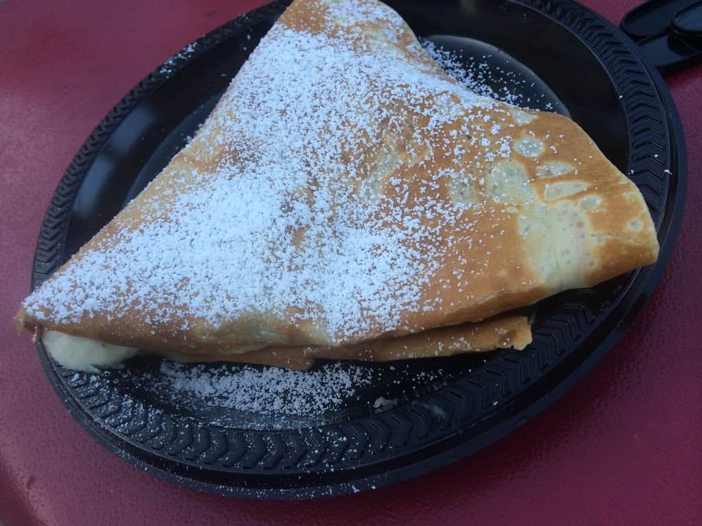 NOT-gluten-free crepe folded, on a plate, and sprinkled with powdered sugar