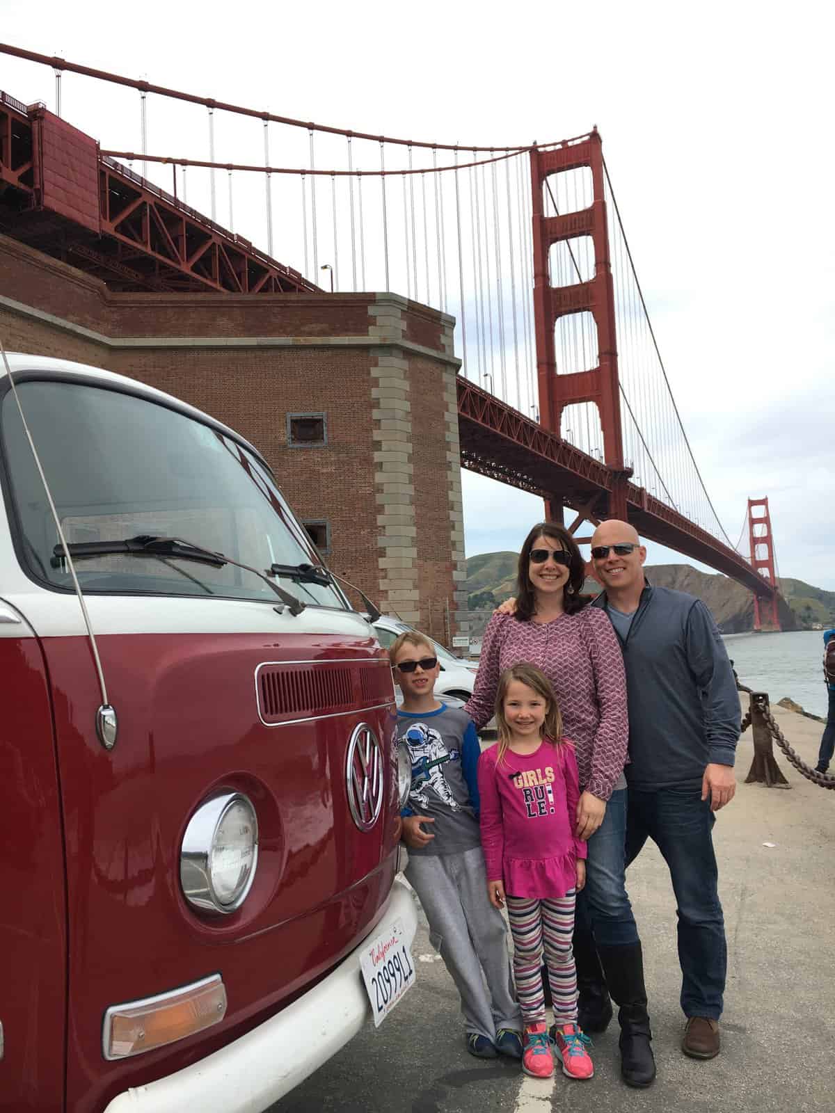 Heather and family next to VW bus, in front of Goldengate Bridge on their gluten-free San Francisco getaway