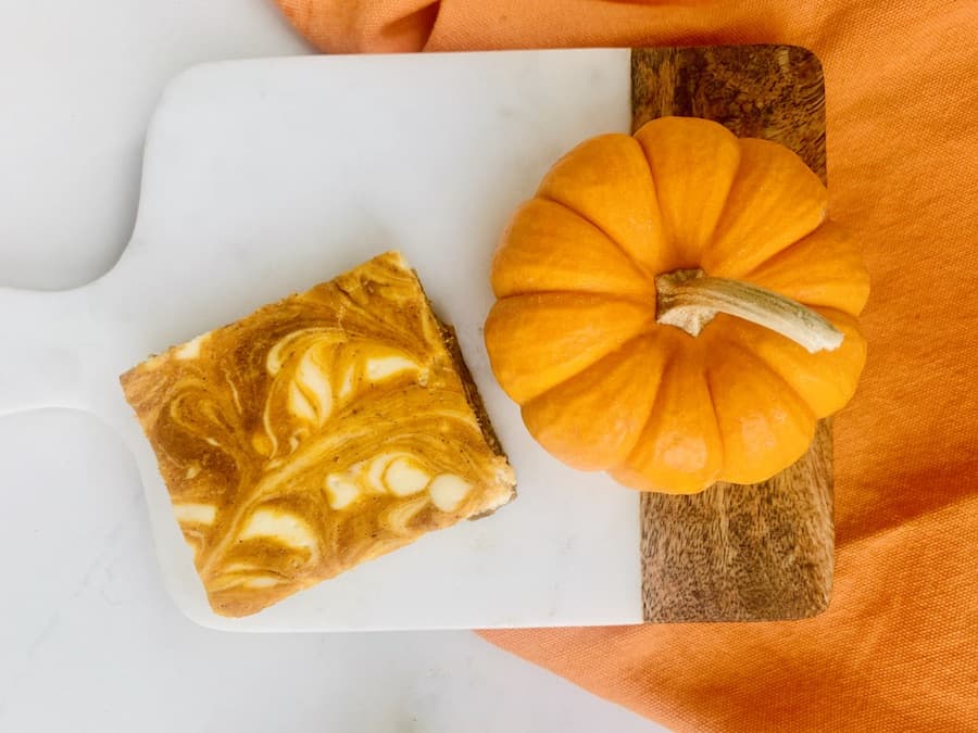 gluten-free pumpkin cheesecake bar on a red and white Currier & Ives plate