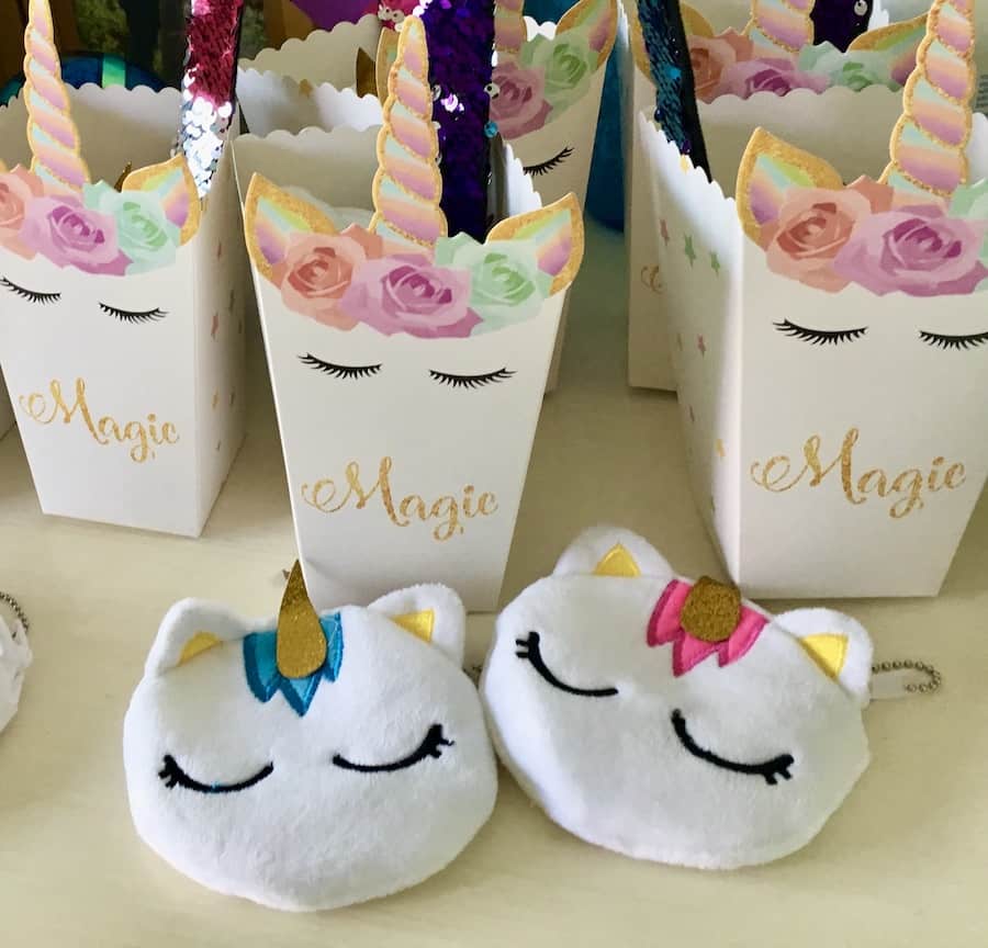 unicorn party favor boxes with unicorn-kitty coin purses in the foreground