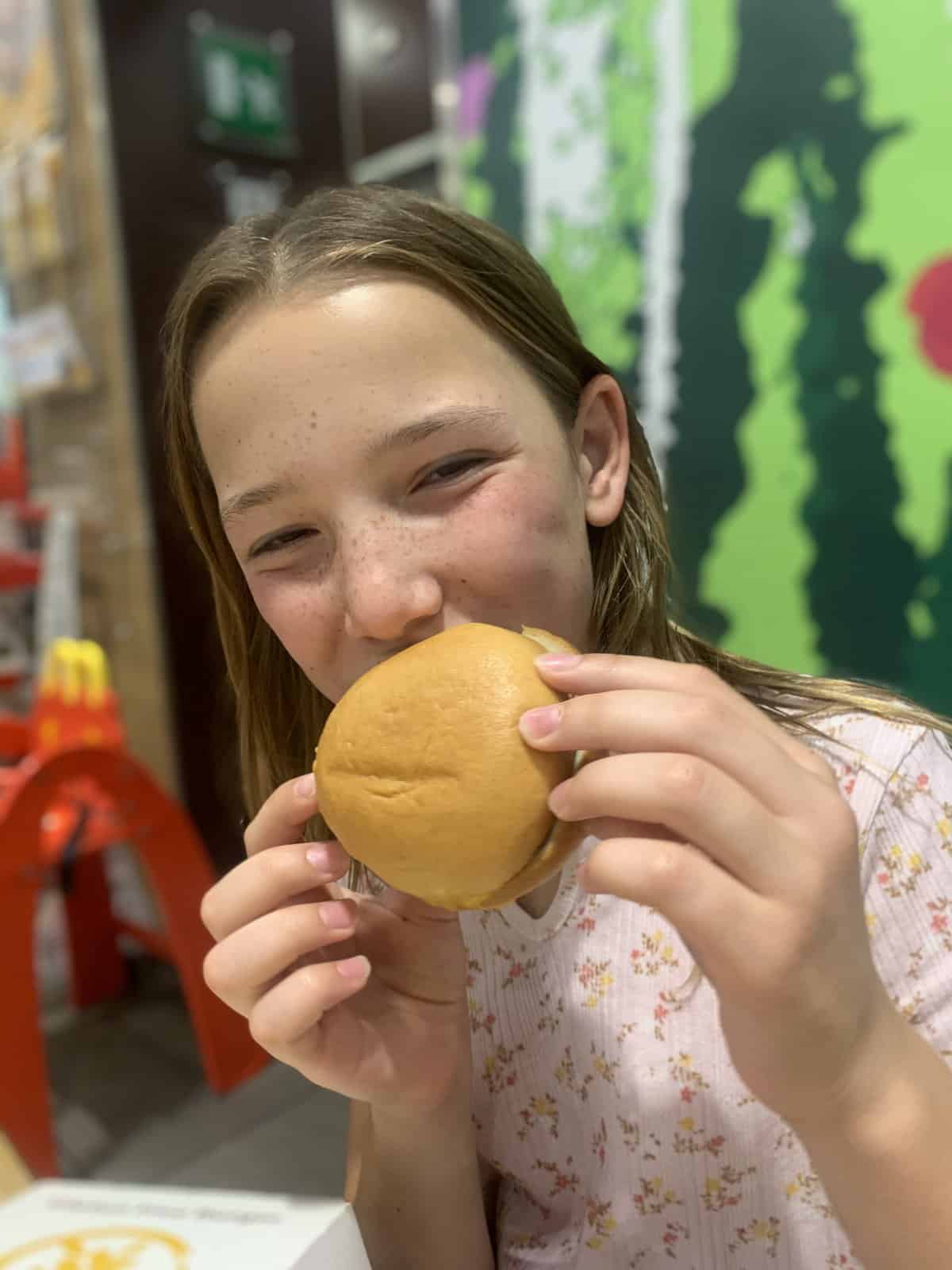 Miss E happily eating a gluten-free McDonald's cheeseburger