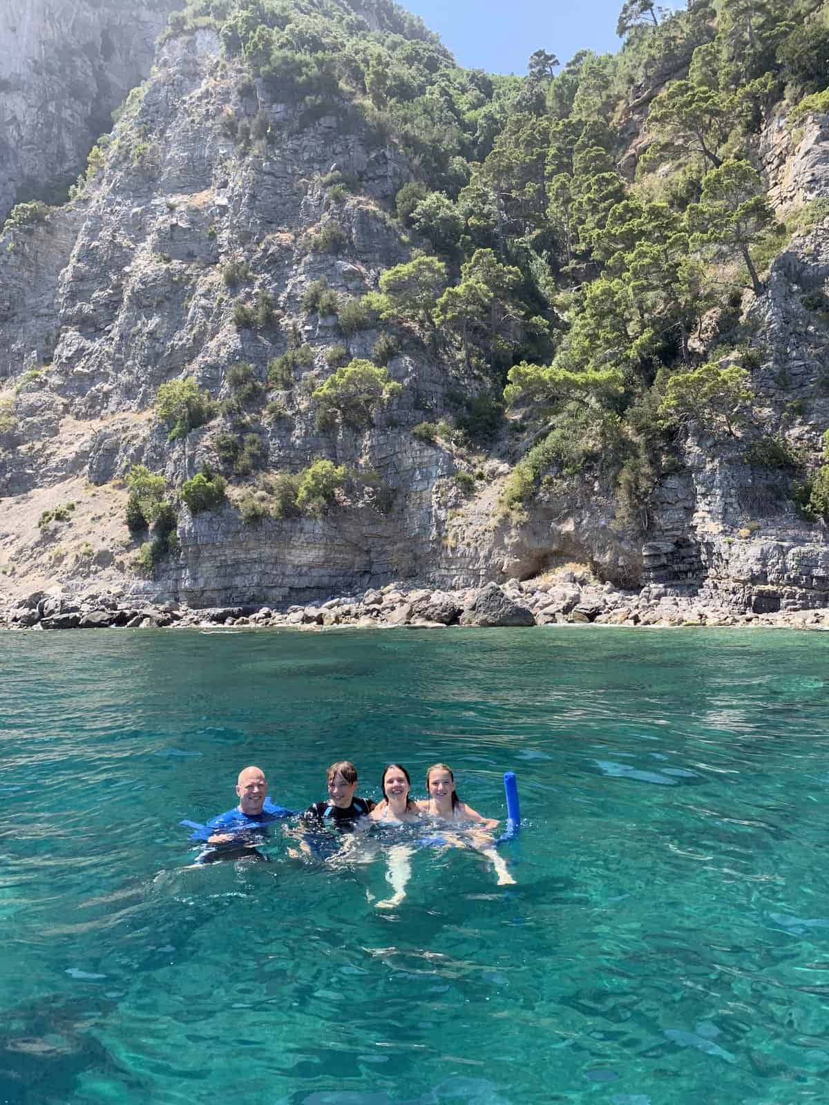 Family in the sea with Capri in the background