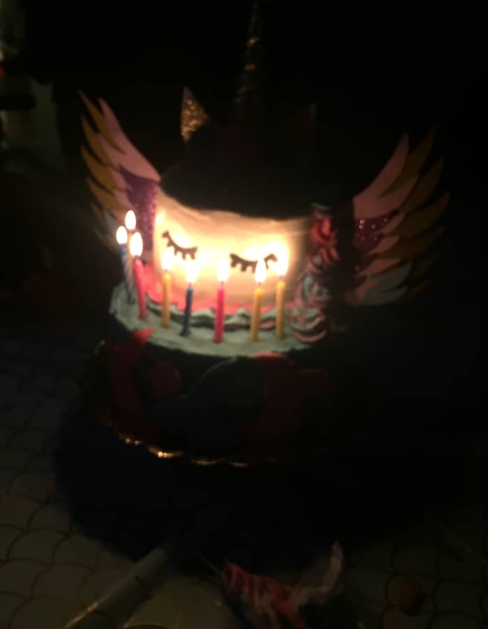 glowing candles on the uni-pega-mer-kitty gluten-free birthday cake