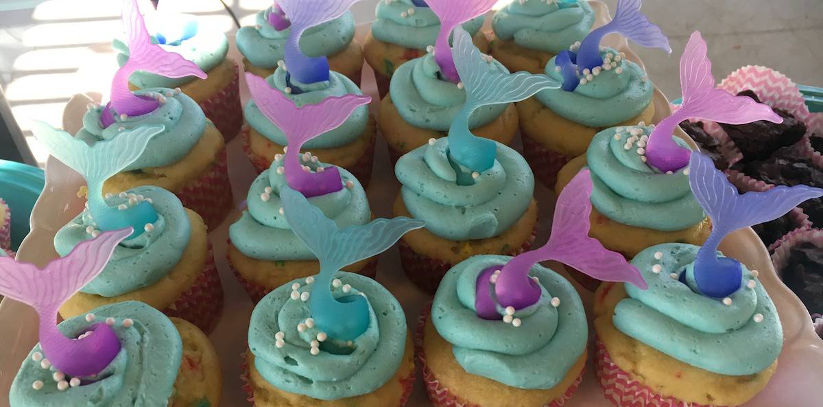gluten-free mermaid party cupcakes with gluten-free funfetti cupcakes, gluten-free aqua frosting, white pearl sprinkles and blue and aqua mermaid tail rings for cupcake toppers