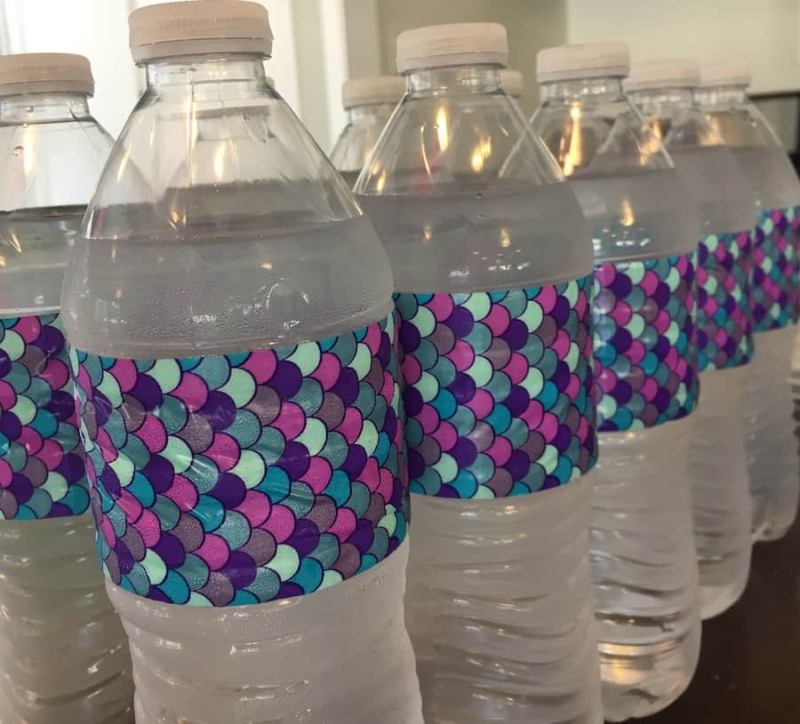 water bottles wrapped with pink, purple and aqua mermaid scale duct tape as a themed decoration
