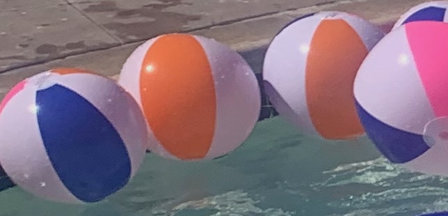 five blue, orange, white and pink classic beach balls in a baby pool