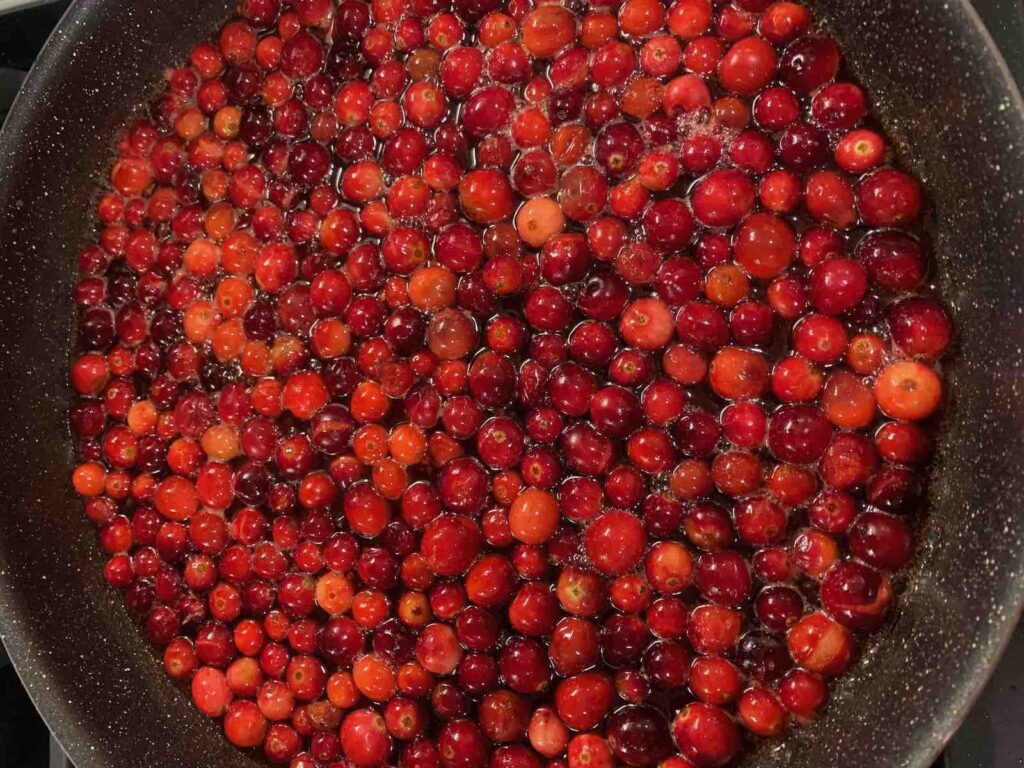 Unpopped cranberries in a skillet.