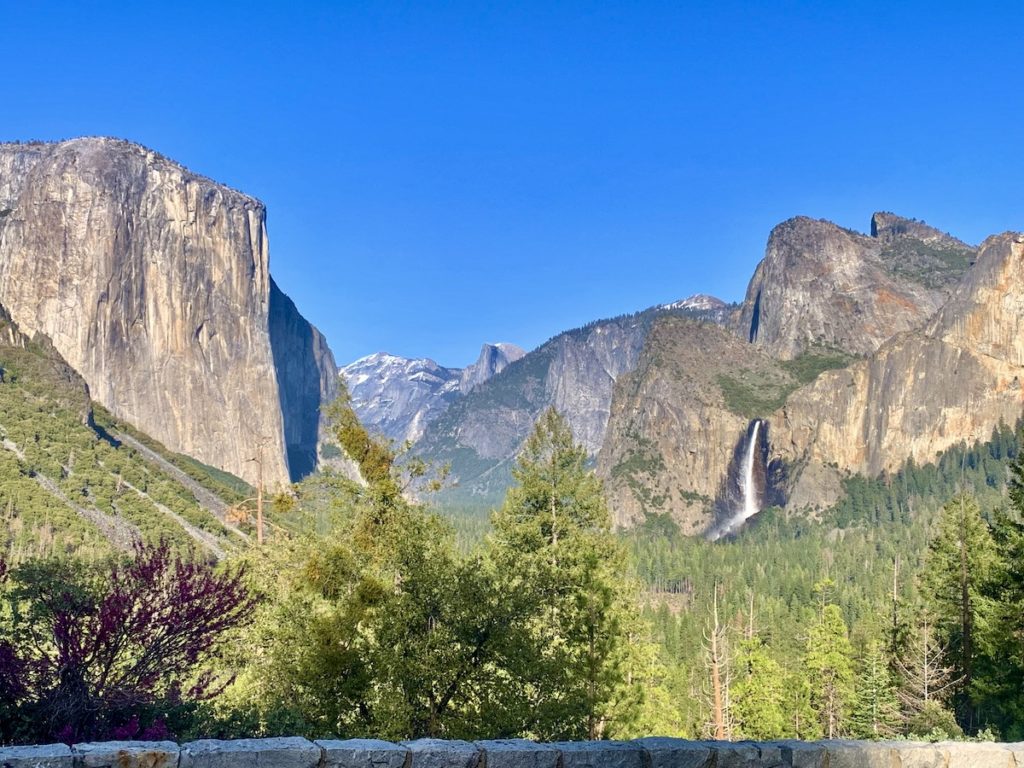 Tunnel View photo spot: view ofYosemite Valley filled with pine trees, granite peaks towering around the sides and a waterfall in the lower right