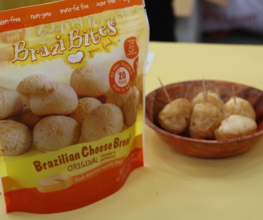 Brazi bites bag (text: Brazi Bites, Brazilian Cheese Bread), next to a small bowl with a handful of cookies Brazil bites with toothpicks