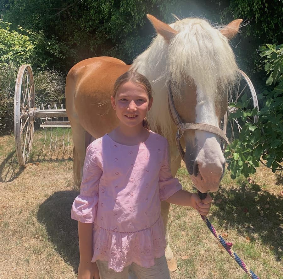 Miss E in a pink dress with a horse