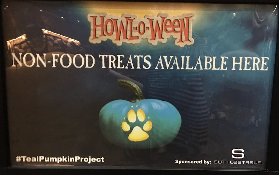 Sign, Text: Howl-o-ween, Non-Food Treats Available Here, #TealPumpkinProject with spooky background and a teal pumpkin, with a glowing wolf paw carved into the front of the pumpkin 