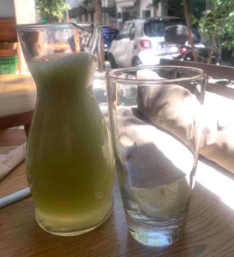 fresh lemonade in a carafe next to an empty glass