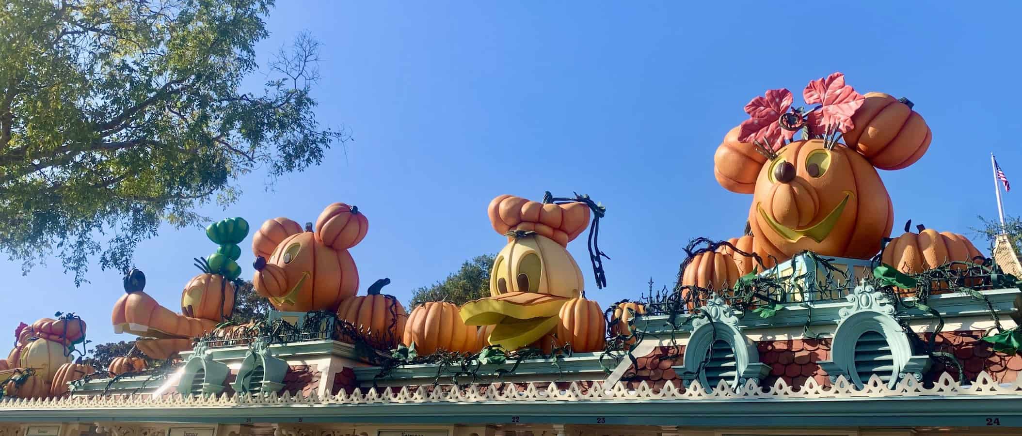 top of Disneyland entrance, Disney characters' heads carved out of pumpkins, left to right, Daisy, Goofy, Mickey, Donald, Minnie