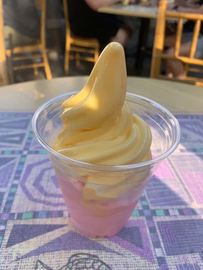 a gluten-free Dole Whip "swirl" with mango on top and watermelon the bottom on a table