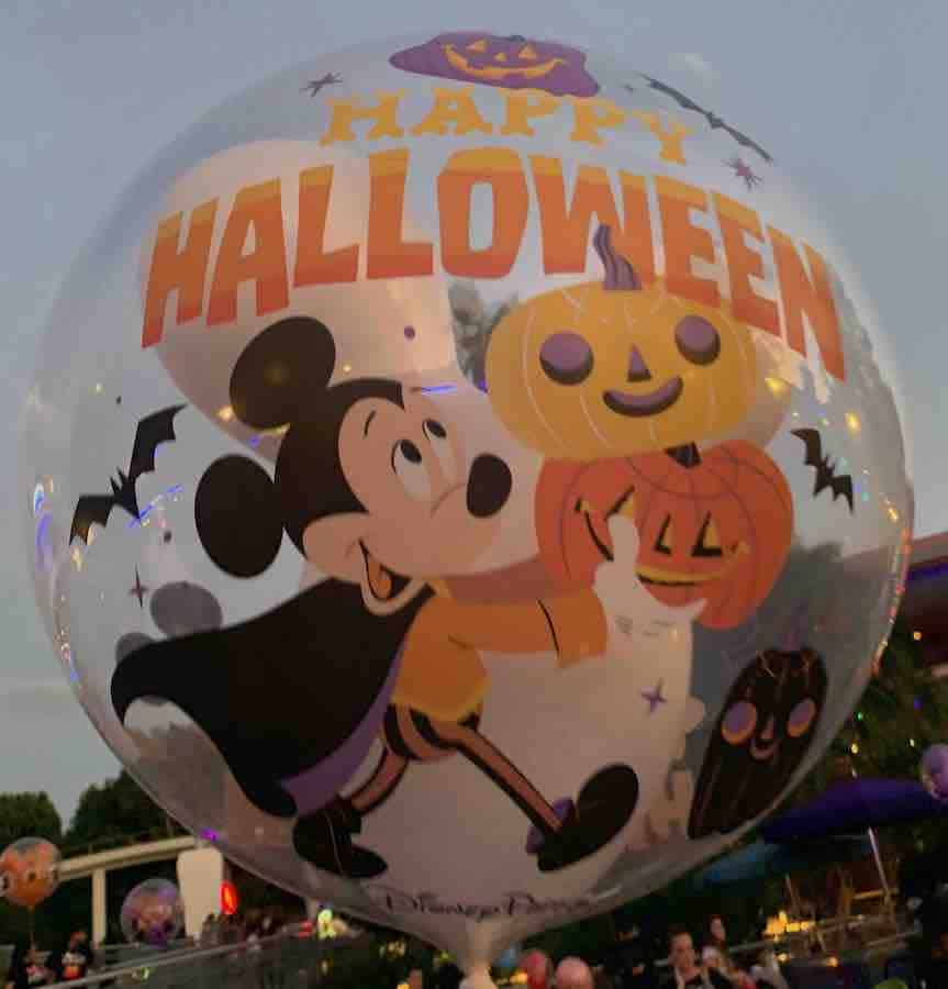 Disneyland Halloween balloon with text:  "Happy Halloween" with a white Mickey head inside and an image of Mickey holding pumpkins on the outside
