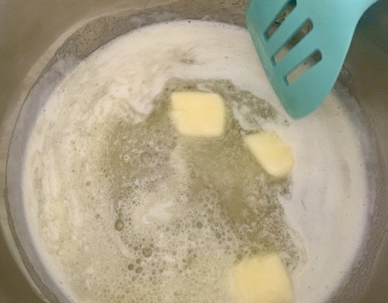 butter melting in a pan with an aqua spatula in the pan