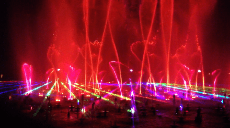 red lights and fountains swirling in the Disney California World of Color show