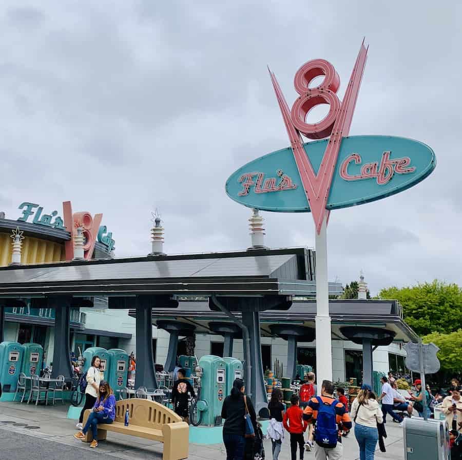 sign for Flo's V8 Cafe with guests walking around and "gas pumps" outside the restaurant