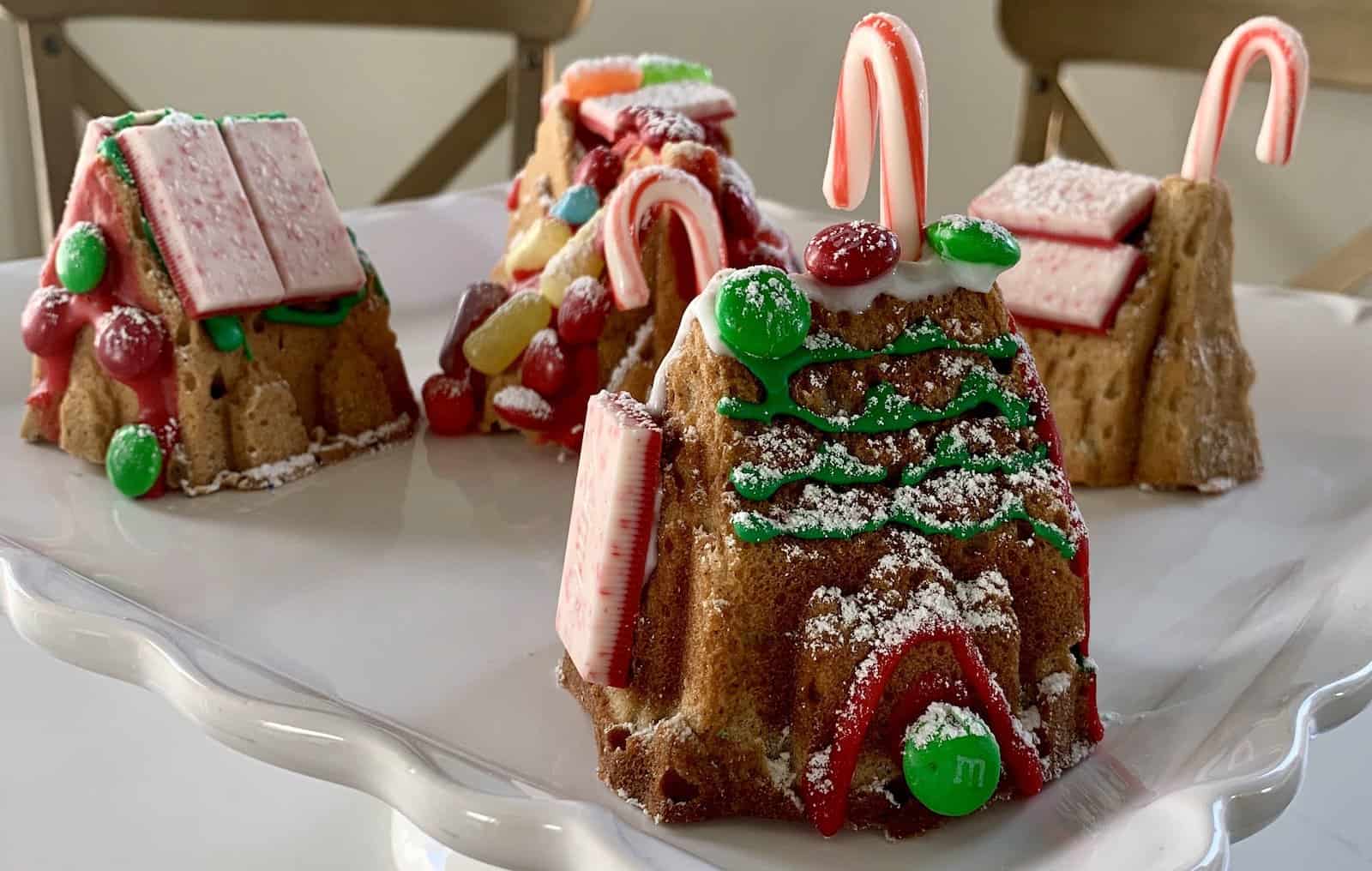 a tray of decorated mini gluten-free gingerbread house cakes