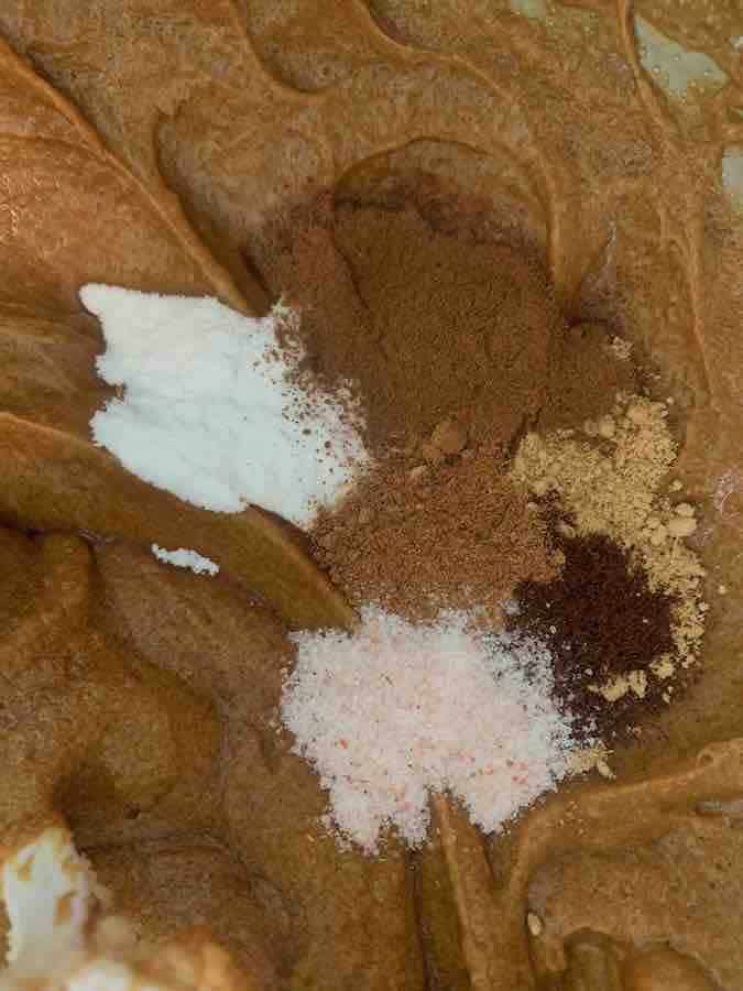 spices being added to dough for gluten-free gingersnap cookies