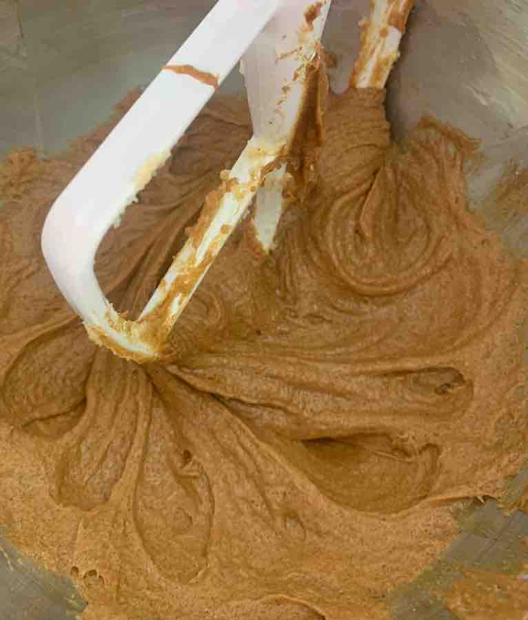 a white stand-mixer beater mixing the wet ingredients for gluten-free gingersnaps