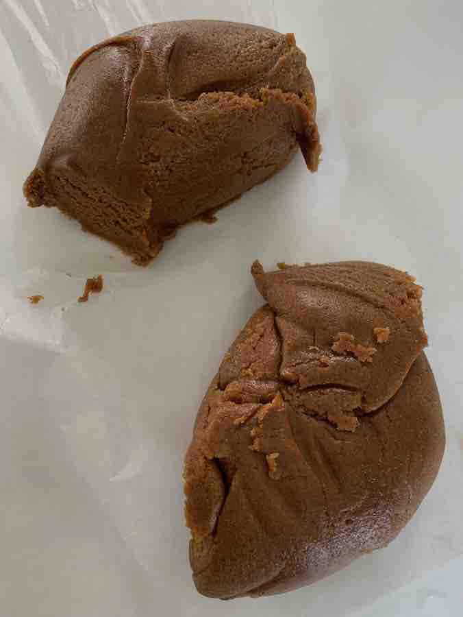 2 balls of gluten-free gingersnap dough on wax paper