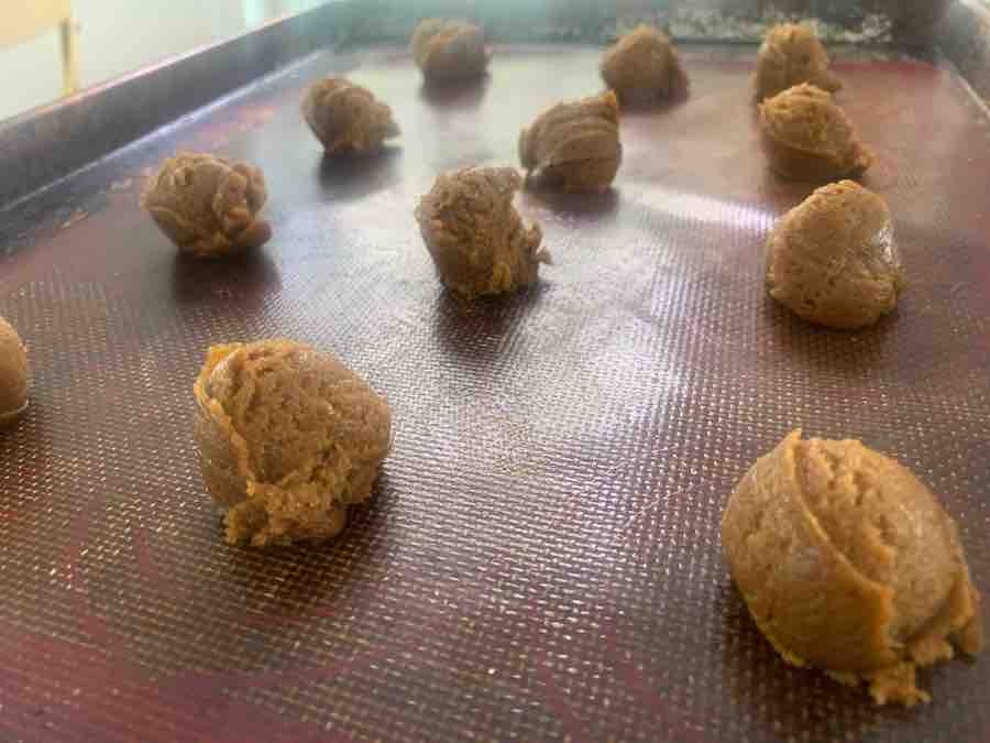 unbaked balls of gluten-free gingersnaps on a silicone baking mat