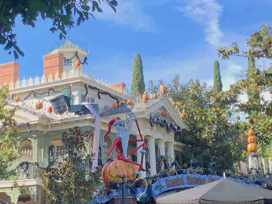 exterior view of Haunted Mansion Holiday, Nightmare Before Christmas, with Jack Skellington in a Santa outfit sitting on a jack-o-lantern