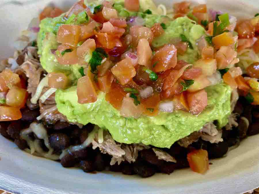 Chipotle gluten-free burrito bowl with rice, black beans, carnitas, guacamole and salsa