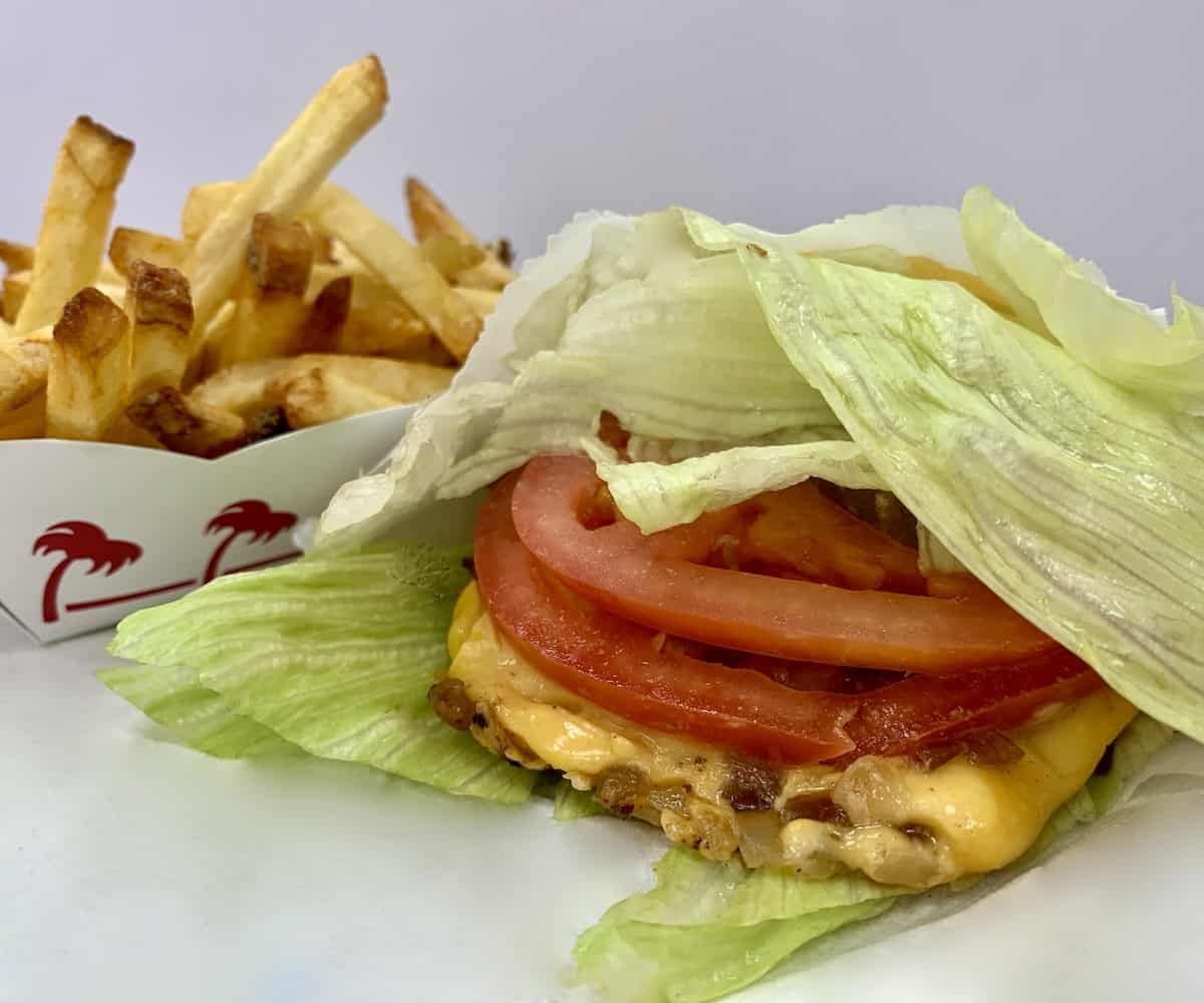 Gluten-Free protein-style cheeseburger in a lettuce-wrap with French fries.