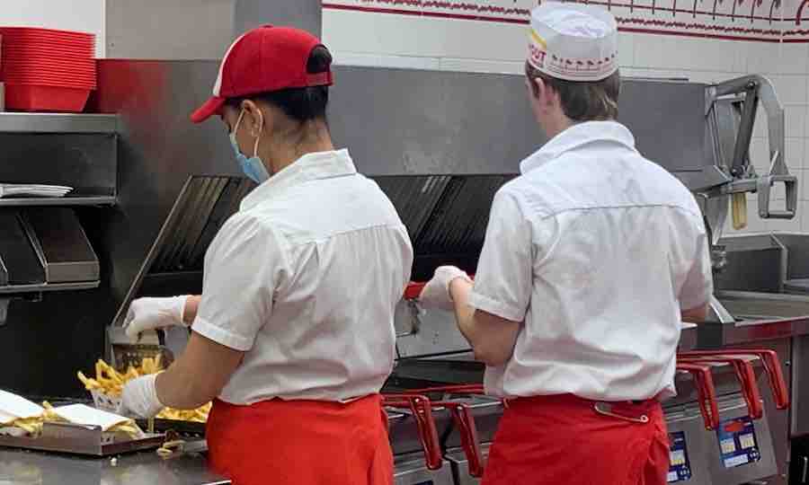 2 In-N-Out employees making gluten-free fries in a dedicated fryer