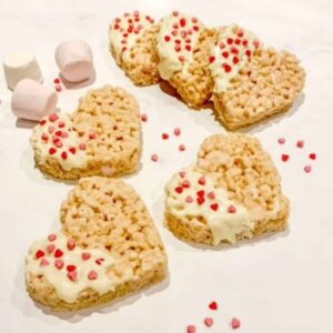 heart shaped rice crispy treats, corners dipped in white chocolate and covered with sprinkles.... a few marshmallows and sprinkles loose on the counter