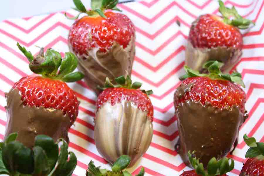gluten-free milk chocolate and white chocolate-covered strawberries on chevron red-white parchment paper