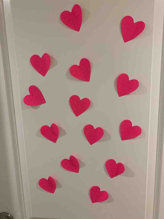 a door covered with pink heart post-it notes