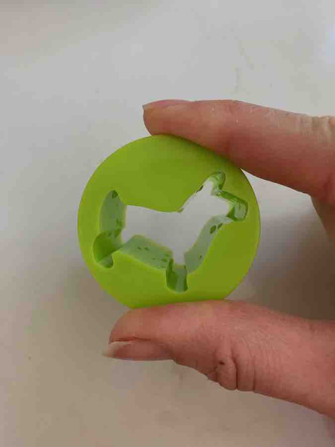 a green cookie cutter shaped like a dog