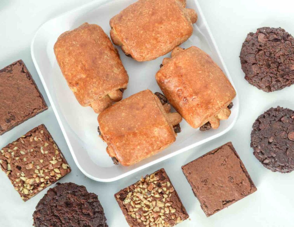 gluten-free pain au chocolat on a white plate... surrounded by chocolate cookies and brownies on a white counter
