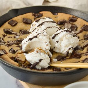 giant gluten-free chocolate chip cookie with ice cream in a cast iron skillet