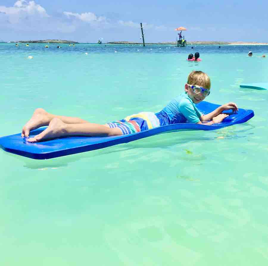 CJ with goggles on a blue raft in the ocean