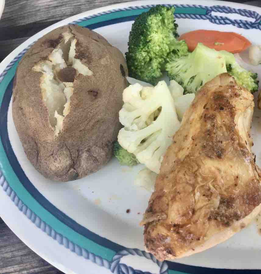 plate with baked potato, mixed veggies and grilled chicken