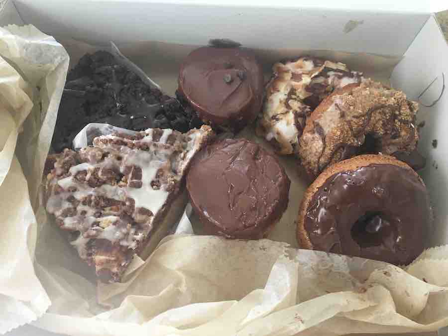 gluten-free baked goods in a box from Erin McKenna's bakery: brownie, coffee cake, 2 chocolate cupcakes and 3 donuts