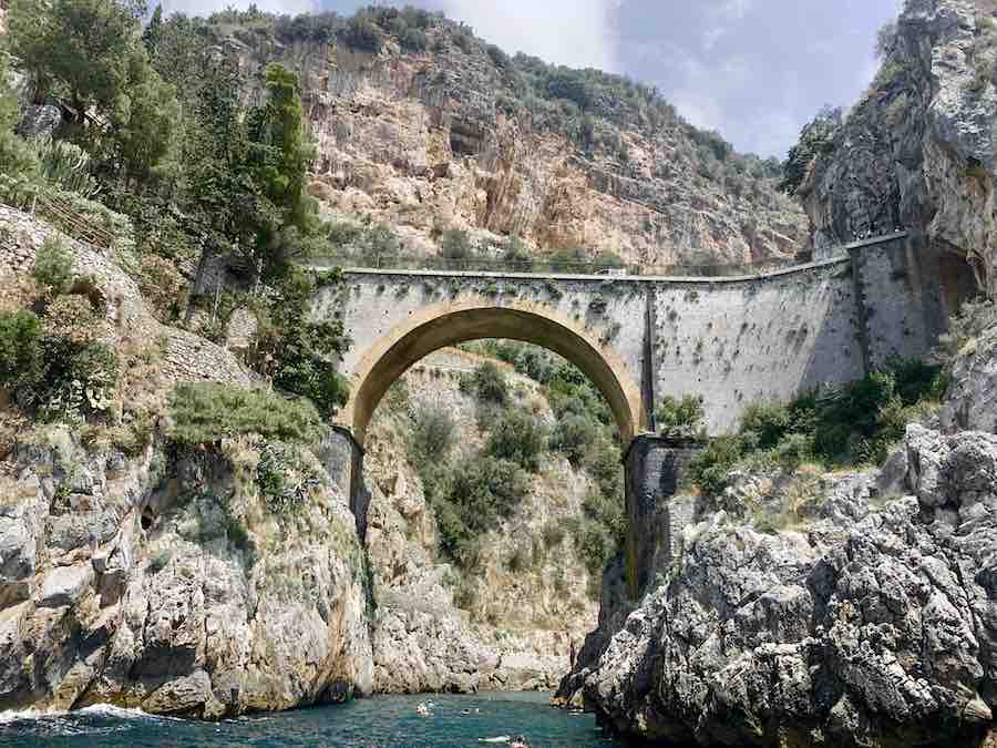a bridge with a very high arch, and a swimming hole below, on the Amalfi coast