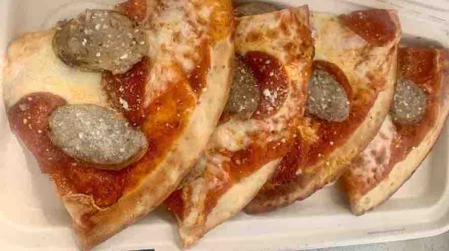 gluten-free sausage and pepperoni pizza, with four slices separated and spread in a row slightly on top of each other