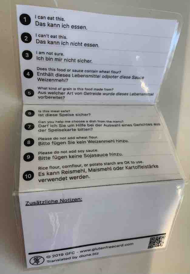 The back of a laminated celiac dining card in German. It says has helpful phrases written in English and German.