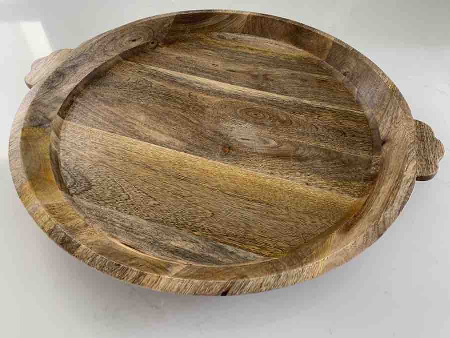 a round, wooden tray with wooden handles