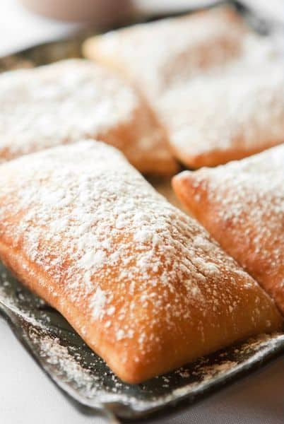 beignets on a plate, covered with powdered sugar