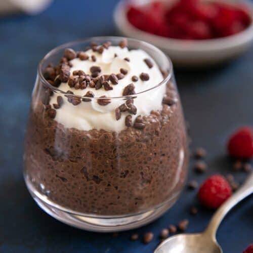 Chocolate Chia Pudding in a glass, topped with whipped cream and chocolate pieces