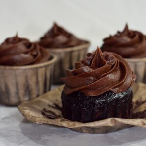 4 Gluten-Free Chocolate Cupcakes with Chocolate Buttercream, one unwrapped