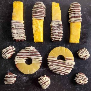 pineapple spears, rings, and pieces dipped in milk chocolate and drizzled in white chocolate