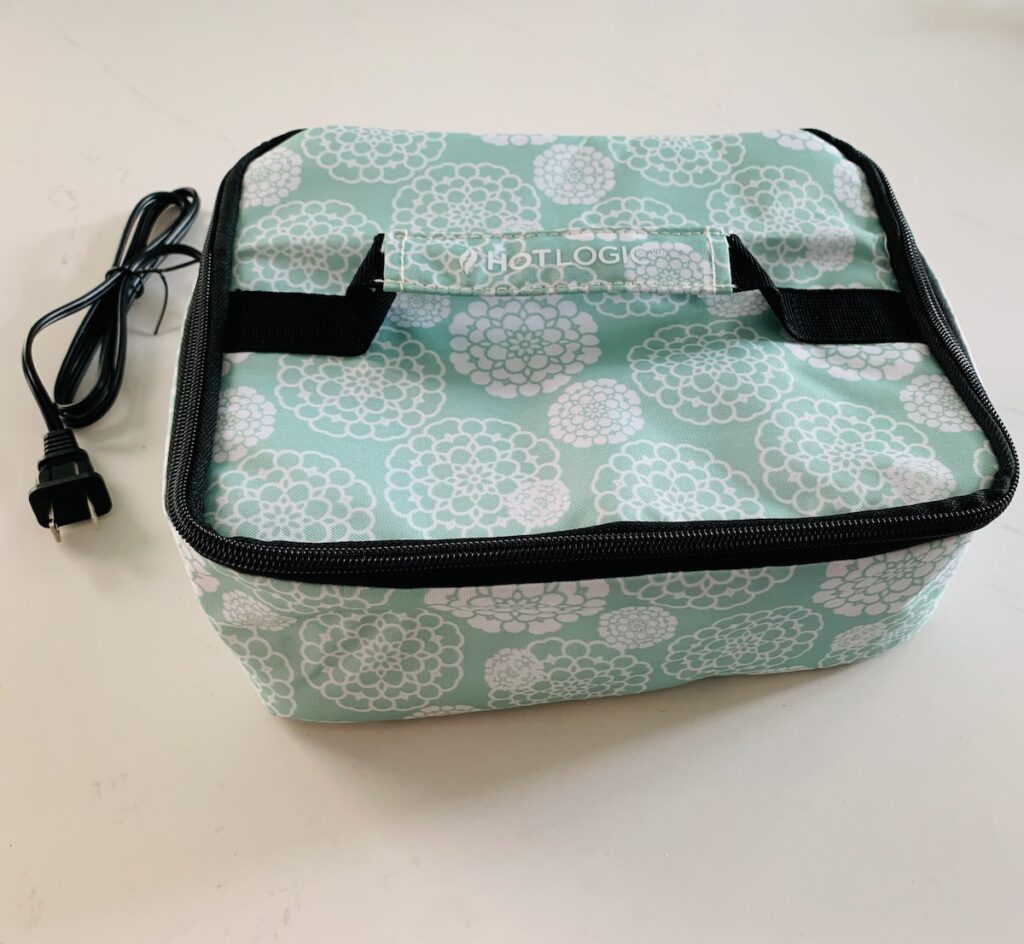 Hot logic container with visible plug. Fabric is light aqua with white flowers.