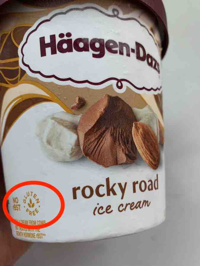 container of haagen-dazs rocky road ice cream with gluten-free symbol (text gluten-free in a circle around a three leaf image, that appears like the very tip/top of wheat) circled in red